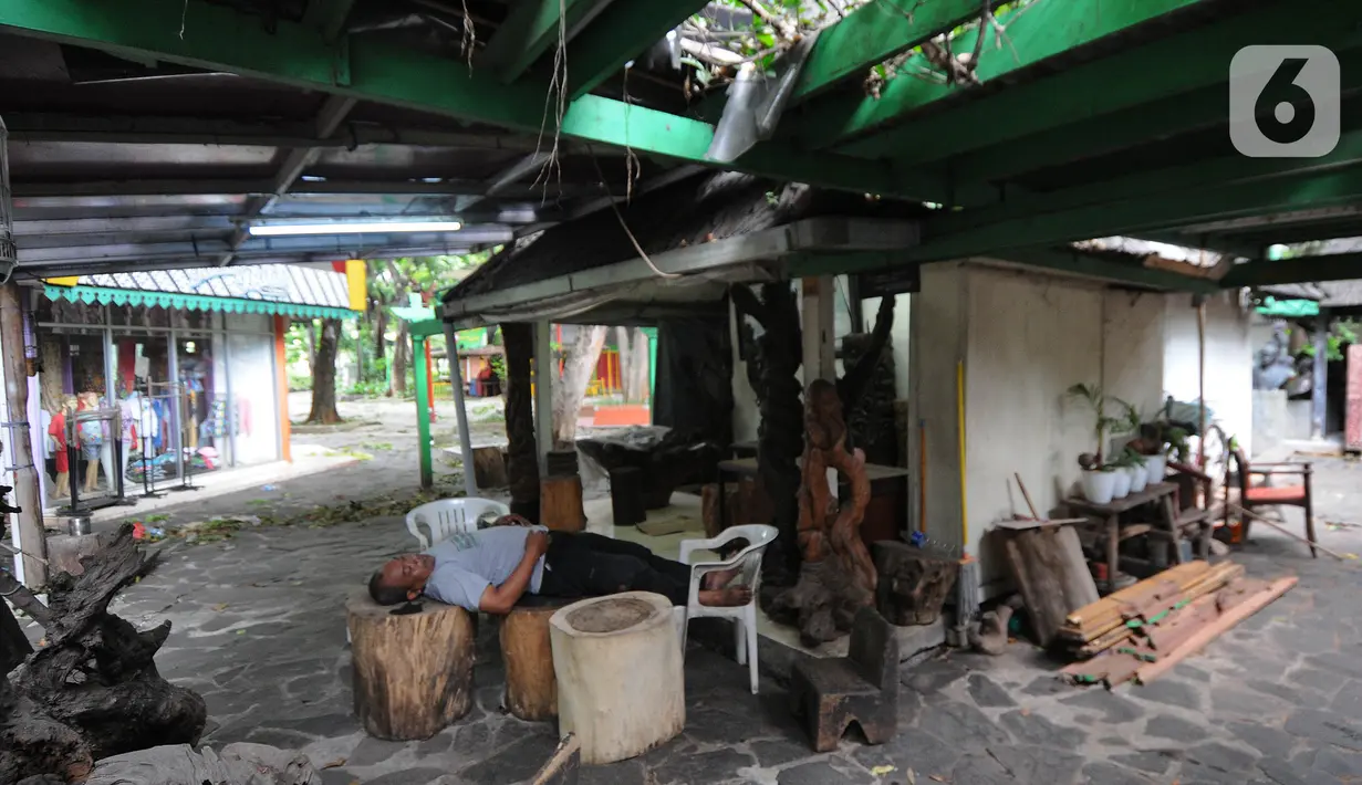 Seniman tertidur di depan kiosnya  di Pasar Seni Ancol, Jakarta, Rabu (24/11/2021). Paska pandemi yang berlangsung dua tahun, sejumlah seniman di Pasar Seni Ancol mulai beraktifitas menjadikan karya-karyanya sebagai sumber daya hidup mereka.