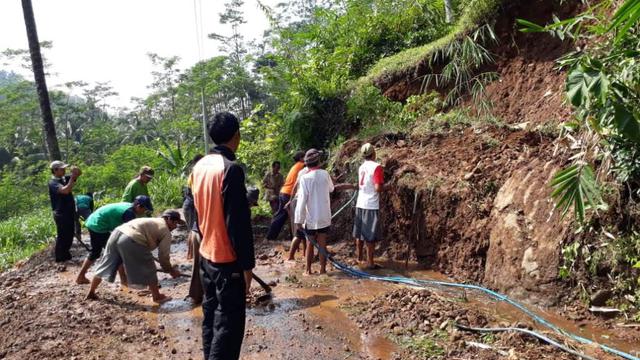 Ratusan warga menyingkirkan lumpur dan material lain yang menimpa jalan penghubung dua desa. (Foto: Liputan6.com/BPBD Banyumas/Muhamad Ridlo)
