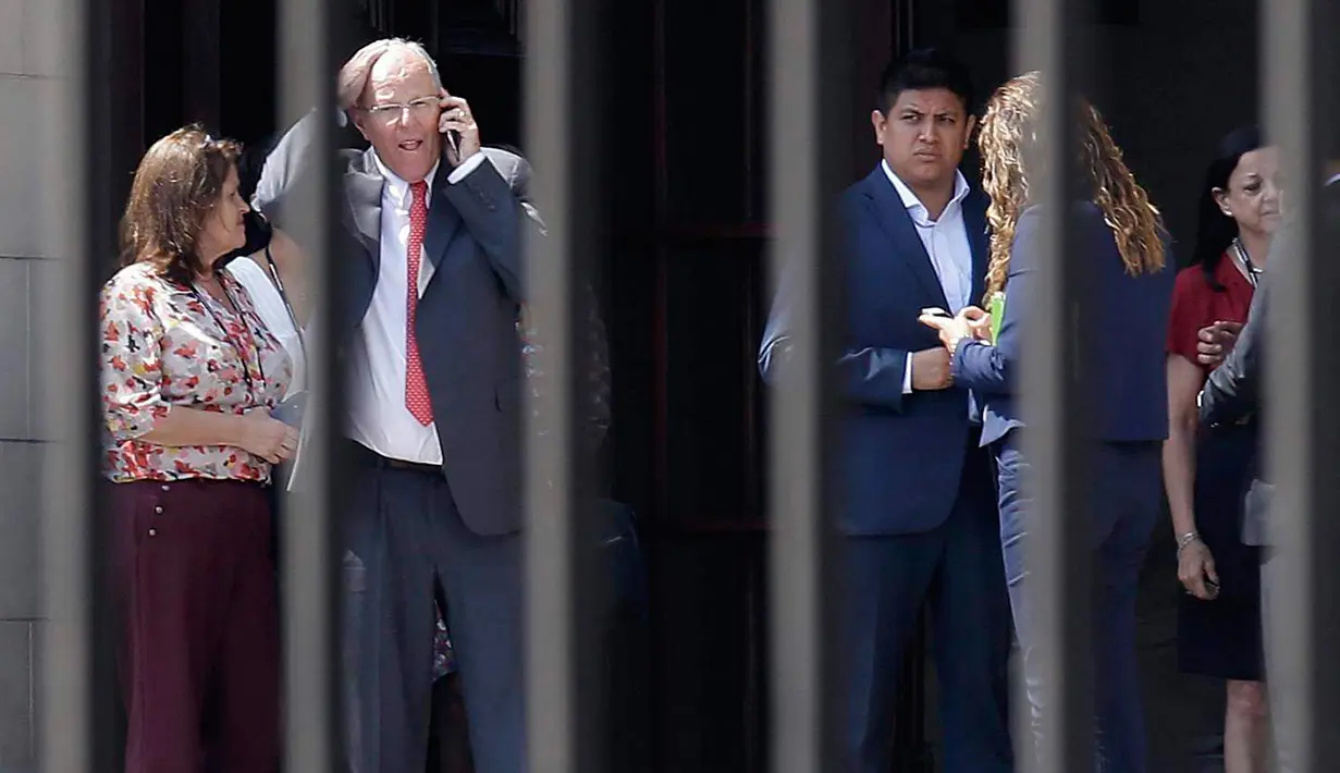 Presiden Peru Pedro Pablo Kuczynski (kedua kiri) berbicara di ponselnya saat bersiap mengosongkan Istana Pemerintah atau House of Pizarro, di Lima, Peru (21/3). (AP/Martin Mejia)