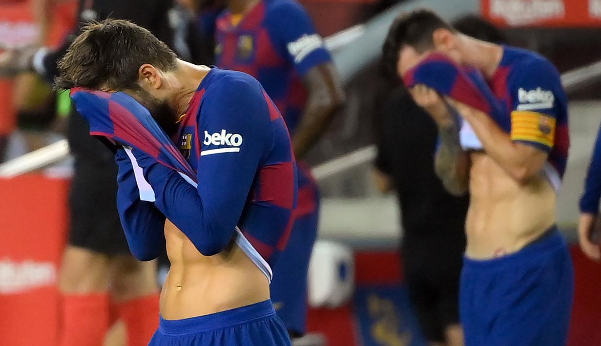 Pemain Barcelona, Lionel Messi dan Gerard Pique, tampak kecewa usai dikalahkan Osasuna pada laga lanjutan La Liga pekan ke-37 di Camp Nou, Jumat (17/7/2020) dini hari WIB. Barcelona kalah 1-2 atas Osasuna. (AFP/Lluis Gene)