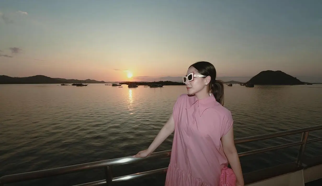 Gaya riasannya itu serasi dengan pakaian serba pinknya. Di momen itu, Nagita mengenakan dress panjang sleeveless warna pink berkerah dan berkancing depan. Serta mengenakan kacamata hitam bingkai putih pink dari Loewe.  [@raffinagita1717].