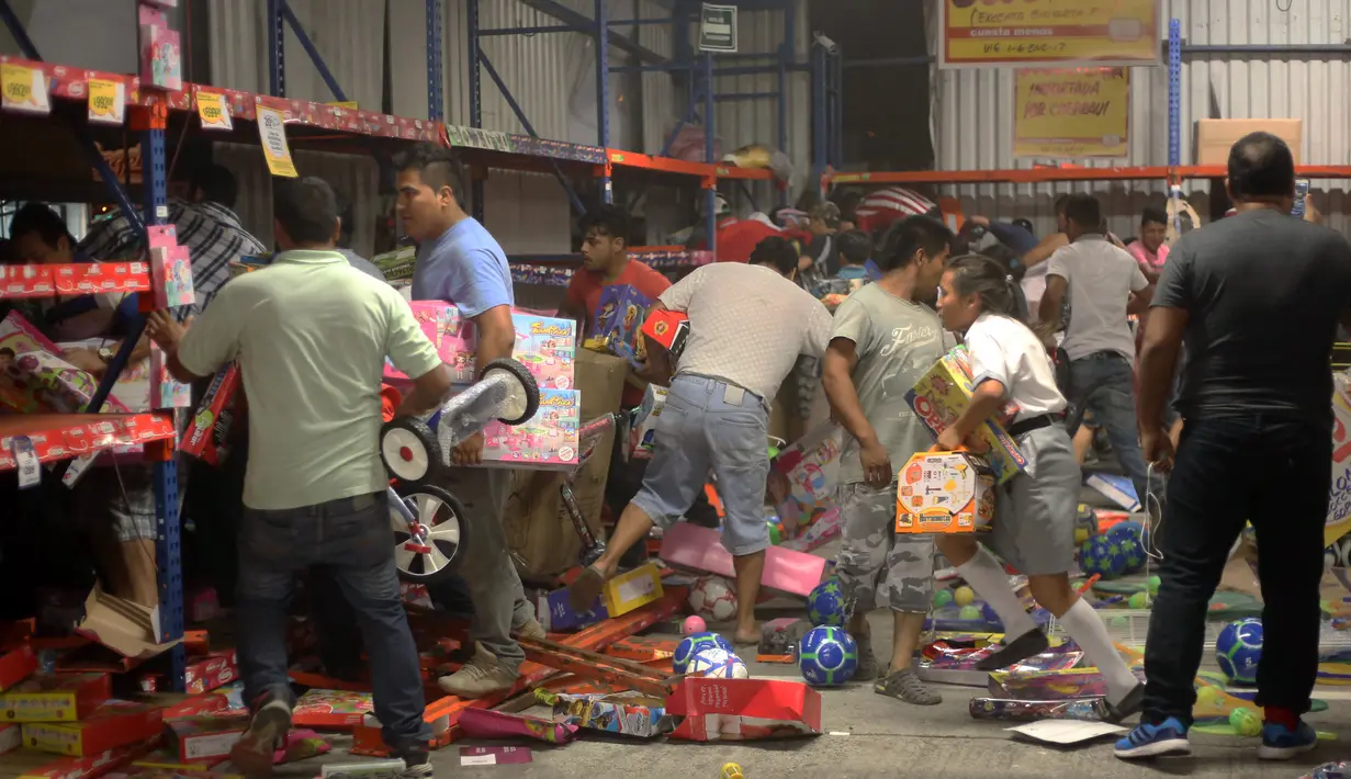 Sejumlah orang menjarah berbagai produk mainan di sebuah toko di negara bagian Veracruz, Meksiko, Rabu (4/1). Penjarahan terjadi di sejumlah toko di Meksiko, seiring berlangsungnya unjuk rasa memprotes kenaikan harga bahan bakar minyak. (Ilse HUESCA/AFP)