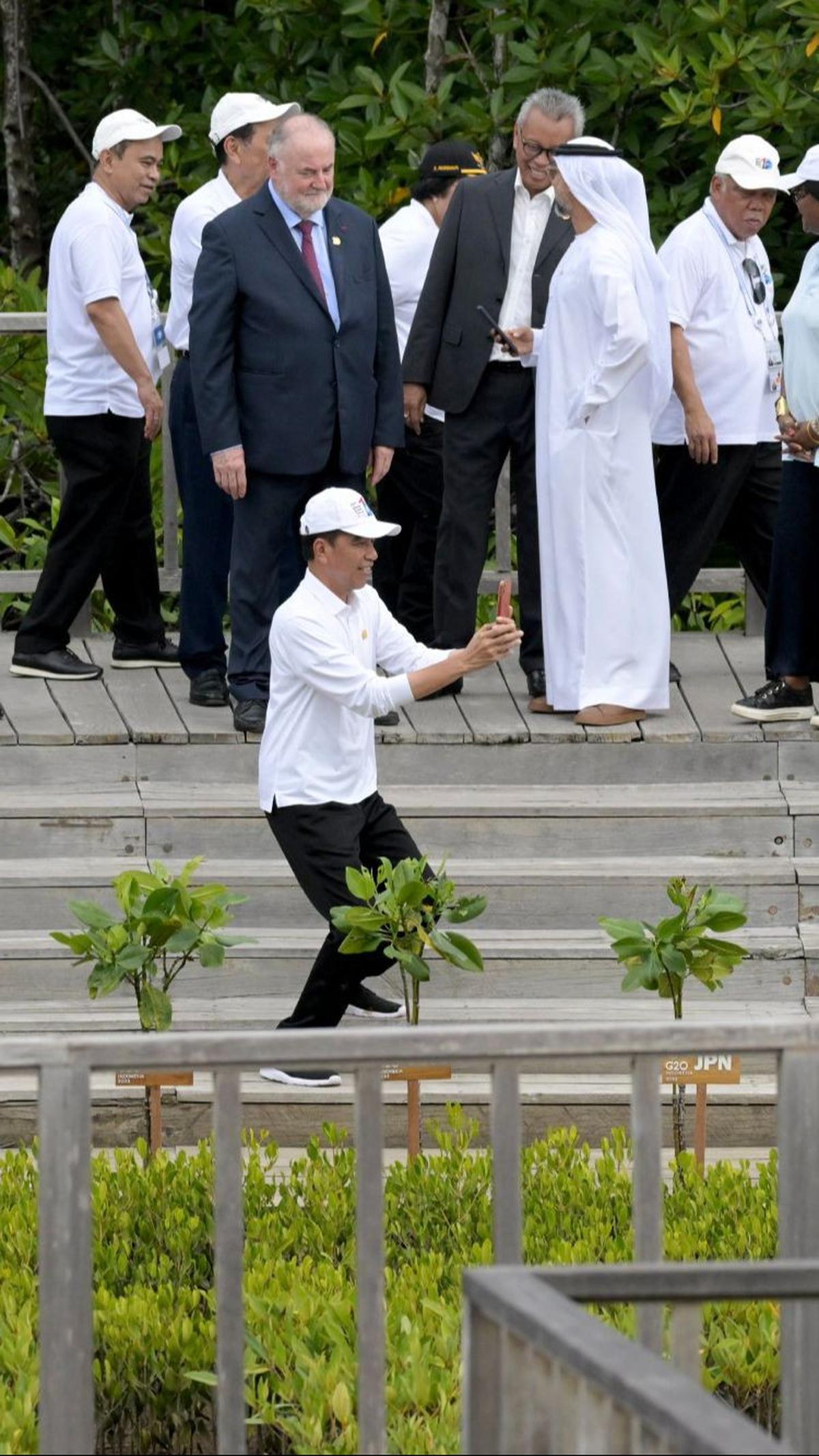 Jokowi lantas mengambil posisi untuk memotret Barbara Pompili. Tak hanya sekali, Jokowi tampak memotret Barbara dengan beberapa angle.&nbsp;Foto: Sonny Tumbelaka/Pool/AFP