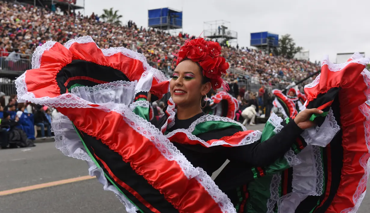 Penari asal Meksiko saat tampil pada parade mawar ke 128 di Pasadena, California, AS (2/1). Parade ini menghadirkan kendaraan berhias bunga, marching band, serta unit pasukan berkuda yang diikuti para atlet football. (AP Photo/Michael Owen Baker)