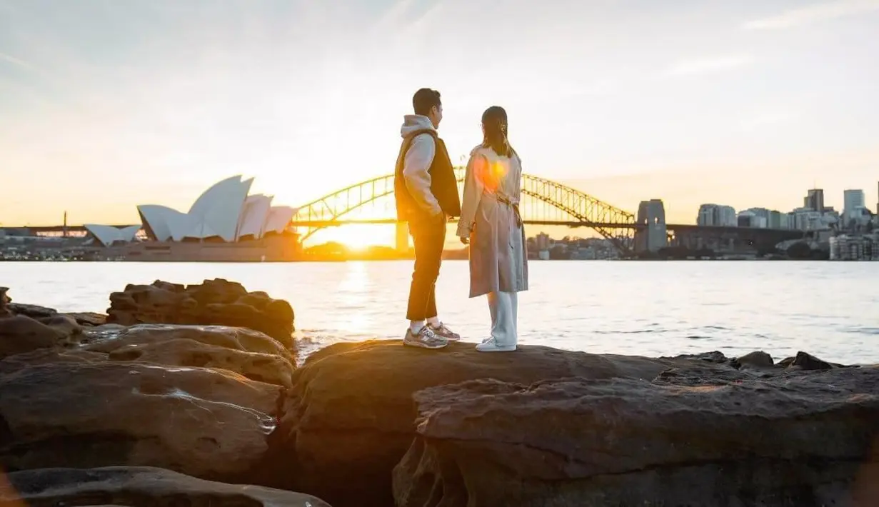 Pebulutangkis peringkat 2 BWF dari Indonesia itu menyematkan cincin ke jari manis Mitzi. Pria disapa Ginting itu melamar sang kekasih di Sydney Harbour Bridge, Australia. [Instagram/sinisukanthony]