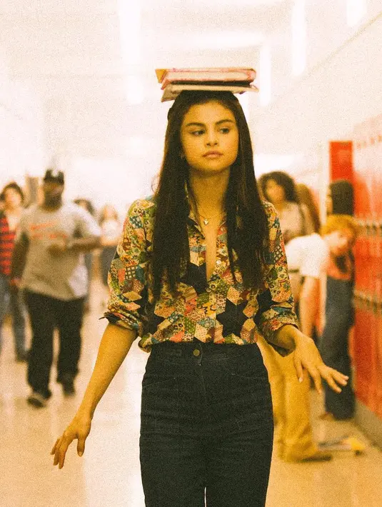 Kali ini Selena Gomez memadukan celana jeansnya dengan kemeja bermotif abstrak yang lengan panjangnya digulung. Rambut panjangnya pun dibiarkan terurai begitu saja, hanya ia menjepit bagian poninya ke  arah samping. (Instagram/selenagomez)