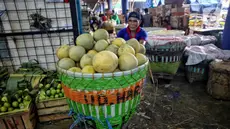 Pedagang mendorong gerobak berisi buah segar yang akan di jual di pasar Kramat Jati, Jakarta, Kamis (13/3/2025). (Liputan6.com/Angga Yuniar)