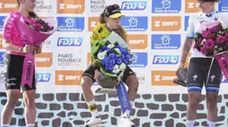 Pembalap Team Visma-Lease, Pauline Ferrand-Prevot berusaha menjunjung trofi kemenangan Paris Roubaix Femmes 2025 pada Sabtu (12/04/2025) waktu setempat. Perlombaan tersebut menempuh 148,5 km dari Denain hingga Roubaix, Prancis. (AP Photo/Thibault Camus)