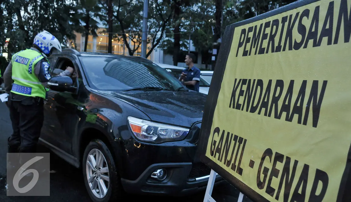 Petugas Kepolisian melakukan penilangan kepada pelanggar ganjil genap di Bundaran HI, Jakarta, Selasa (30/8). Sejumlah kendaraan masih didapati melanggar aturan ganjil genap yang telah resmi diberlakukan. (Liputan6.com/Yoppy Renato)