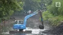 Pekerja mengoperasikan alat berat excavator untuk mengangkat material endapan lumpur di kanal sungai perkantoran Kuningan Jakarta, Rabu (17/2/2021). Pengerukan dilakukan untuk memperlancar aliran air agar tidak terjadi pendangkalan yang mengakibatkan genangan air. (merdeka.com/Imam Buhori)