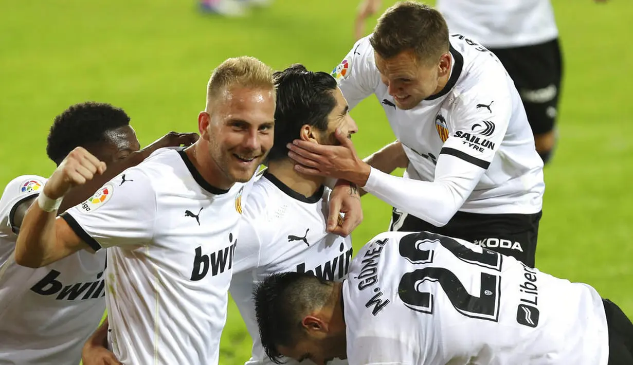 Para pemain Valencia merayakan gol yang dicetak ke gawang Real Madrid pada laga Liga Spanyol di Stadion Mestalla, Minggu (8/11/2020). Valencia menang dengan skor 4-1. (AP/Alberto Saiz)
