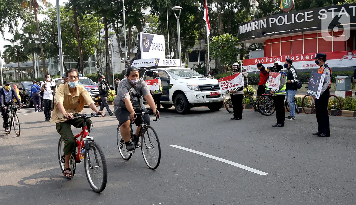 Pengguna sepeda melintas saat sosialisasi penerapan protokol kesehatan PSBB di Bundaran HI, Jakarta, Minggu (13/9/2020). Kepastian pemberlakuan kembali PSBB di Jakarta masih dibahas antara Pemprov DKI dan pemerintah pusat dan akan diumumkan nanti sore. (merdeka.com/Arie Basuki)