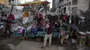 Pedagang Palestina menunggu pembeli pakaian yang dijualnya di samping puing-puing bangunan di Kota Gaza, Minggu (18/7/2021). Bagi warga Palestina yang kehilangan orang-orang terkasih dalam pertempuran antara militan Gaza dan Israel, tidak ada alasan untuk merayakan Idul Adha. (AP Photo/Khalil Hamra)