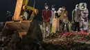 Keluarga menyaksikan pemakaman jenazah dengan protokol covid-19 di TPU Rorotan, Jakarta, Rabu (14/7/2021). Jumlah penambahan kasus baru COVID-19 pada Rabu (14/7/2021) sebanyak 54.517 orang, sehingga total akumulatif ada 2.670.046 orang di Indonesia terkonfirmasi positif. (Liputan6.com/Johan Tallo)