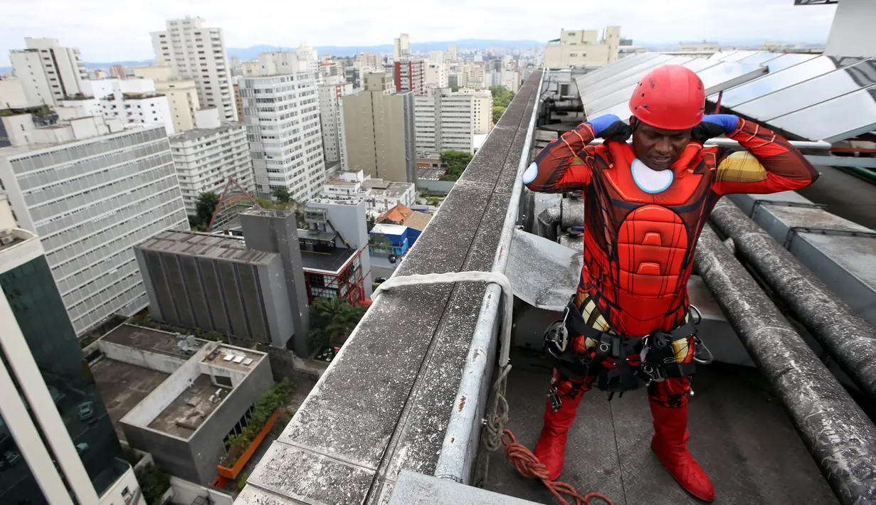 Seorang petugas pembersih kaca menggunakan kostum Iron Man bersiap menghibur pasien anak yang dirawat di RS Infantil Sabara, Sao Paulo, Senin (10/10). Aksi ini bagian dari perayaan Hari Anak Brasil yang diperingati tiap 12 Oktober (REUTERS/Paulo Whitaker)