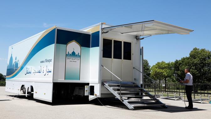 Pewarta mengambil gambar truk masjid saat peresmian di Toyota Stadium, Jepang, Senin (23/7). Truk masjid ini akan dipasang di perkampungan atlet untuk melayani kebutuhan atlet muslim selama Olimpiade 2020. (Mobile Mosque Executive Committee via AP)