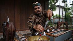 Nasip Hadi Prayitno (51) melakukan ritual jamasan atau pencucian keris di Museum Pusaka TMII, Jakarta, Kamis (20/8/2020). Ritual yang dilakukan setiap memasuki bulan Muharam merupakan upaya mempertahankan keutuhan keris sebagai warisan budaya leluhur yang diakui UNESCO.  (Liputan6.com/Faizal Fanani)