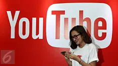 Seorang wanita melintas di depan backdrop YouTube dalam acara yang diselenggarakan YouTube, Jakarta, Selasa (20/10/2015). Menurut Google Indonesia jumlah video yang diunggah pengguna YouTube Indonesia meningkat hingga 600% (Liputan6.com/Immanuel Anton)