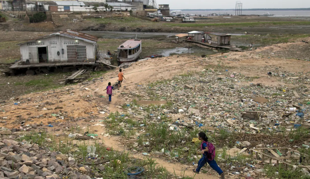 Tampak anak - anak sedang jalan menuju perahu yang di anak sungai Amazon kota Manaus, Brasil, Senin (19/10/2015).  Kekeringan ini merupakan yang terburuk selama 100 tahun terakhir. (REUTERS/Bruno Kelly)