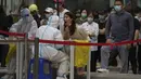 <p>Warga saat diambil sampel usap tenggorokan selama pengujian virus corona massal di dekat kompleks perumahan dan perkantoran komersial di distrik Chaoyang, Beijing, Senin (25/4/2022). Pengujian massal dimulai Senin di distrik itu, rumah bagi lebih dari 3 juta orang di ibu kota China, menyusul wabah COVID-19 yang baru. (AP Photo/Andy Wong)</p>