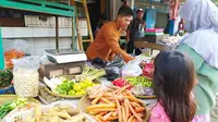 Seorang pedagang tengah melayani pembeli sayuran di salah satu lapak pasar kojengkang Suci, Karangpawitan, Garut, Jawa Barat. (Liputan6.com/Jayadi Supriadin)