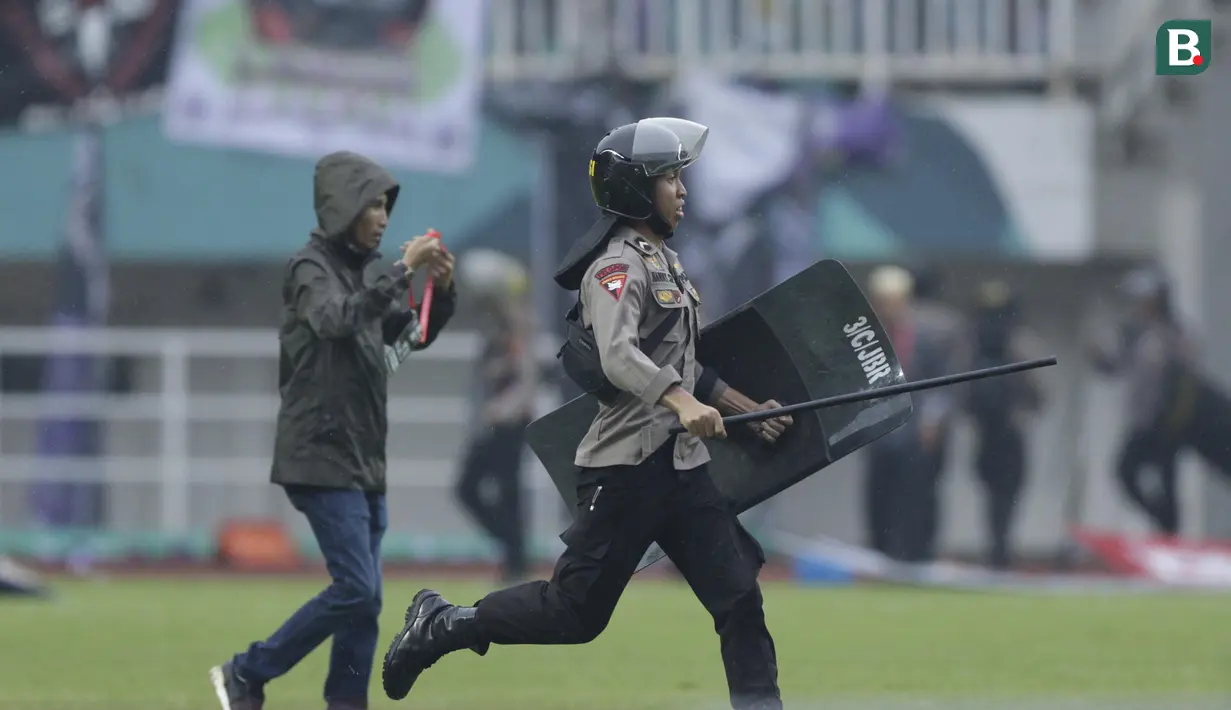 Polisi mengusir suporter Persita Tangerang yang masuk ke lapangan saat melawan Kalteng Putra pada laga Liga 2 di Stadion Pakansari, Jawa Barat, Selasa (4/12). Kalteng menang 2-0 atas Persita. (Bola.com/M. Iqbal Ichsan)