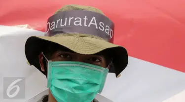 Massa dari Aksi Cepat Tanggap (ACT) melakukan aksi menolak asap dengan menggunakan masker di Patung Kuda, Jakarta, Senin (26/10). Aksi itu menuntut elemen masyarakat agar terlibat langsung dalam upaya penuntasan masalah asap. (Liputan6.com/Faizal Fanani)