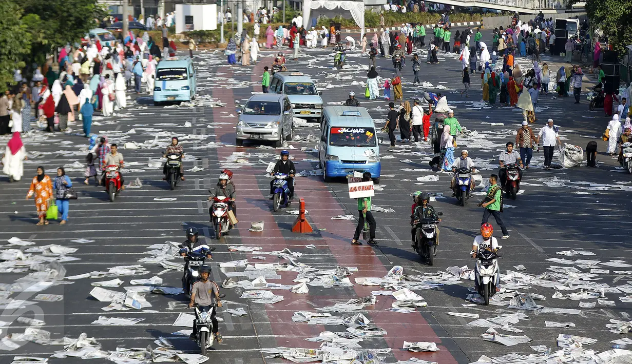 Lembaran koran bekas tak bertuan berserakan menghiasi jalan raya di Jatinegara, Jakarta, Kamis (24/9/2015). Lembaran-lembaran koran tersebut menjadi tak bertuan usai digunakan sebagai alas untuk salat Idul Adha.(Liputan6.com/Yoppy Renato)
