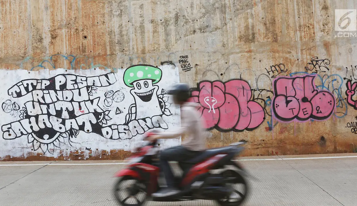 Pengendara sepeda motor melintas di sekitar dinding Jalan Tol Depok-Antasari (Desari), Ciganjur, Jakarta Selatan, Rabu (24/10). Aksi vandalisme menyebabkan dinding tol tampak kumuh dan tidak terawat. (Liputan6.com/Immanuel Antonius)
