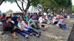 Sejumlah pengunjung beristirahat di area wisata Taman Mini Indonesia Indah, Jakarta, Minggu (19/07/2015). Makan bersama sambil menggelar tiker di tempat wisata menjadi pilihan warga yang mengunjungi tempat wisata TMII. (Liputan6.com/Yoppy Renato)