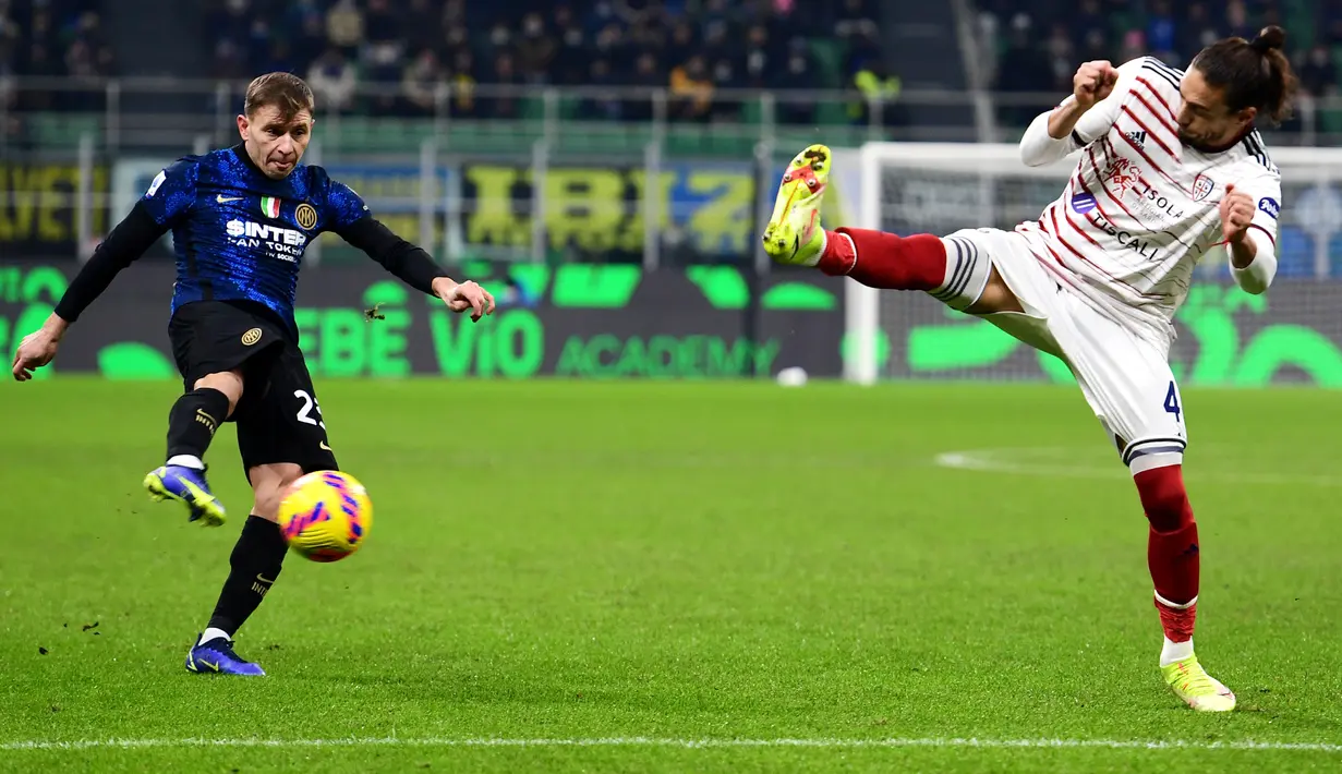 Gelandang Inter Milan Nicolo Barella (kiri) menembak bola ke atas bek Cagliari Martin Caceres pada laga lanjutan Liga Italia pekan ke-17 di Guseppe Meazza, Senin dini hari WIB (13/12/2021). Inter Milan menang telak 4-0 atas tim tamu Cagliari. (Miguel MEDINA / AFP)