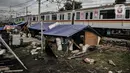 KRL melintasi tenda pengungsian korban penggusuran di tenda pengungsian RT 006/004, Kampung Bandan, Ancol, Jakarta, Kamis (16/7/2020). Korban penggusuran hanya mengandalkan tenda dari terpal dan alas triplek untuk tidur. (merdeka.com/Iqbal S. Nugroho)