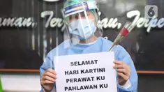 Tenaga medis menunjukkan bunga mawar dan ucapan selamat Hari Kartini di RSUD Kota Tangerang, Selasa (21/4/2020). Komunitas Taman Potret Tangerang menyambut Hari Kartini dengan mendatangi RSUD Kota Tangerang untuk memberikan bunga dan APD kepada tenaga medis perempuan. (Liputan6.com/Angga Yuniar)