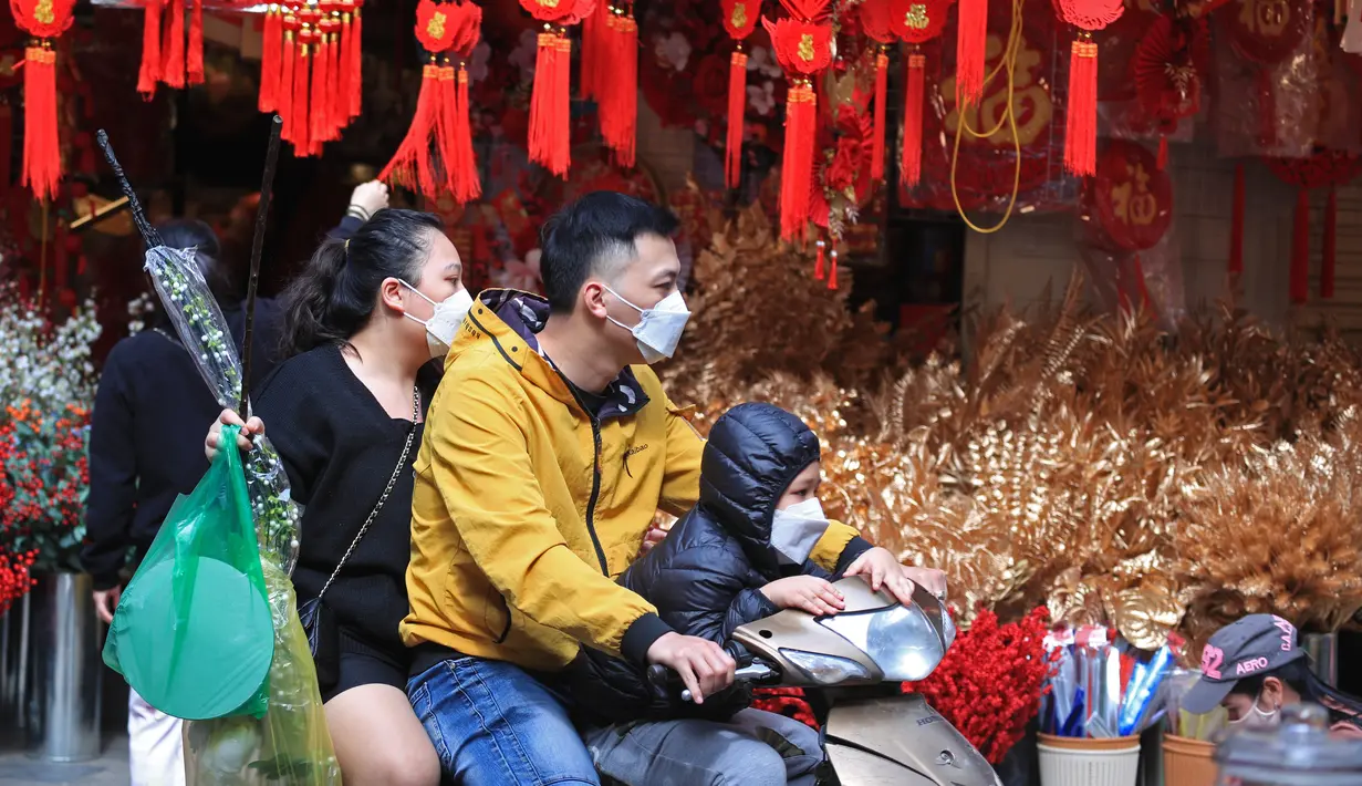 Orang-orang berbelanja di pasar "Tet" Tahun Baru Imlek tradisional di kawasan tua Hanoi, Vietnam, Jumat (28/1/2022). Vietnam merayakan Tahun Baru Imlek yang akan datang di tengah peringatan terhadap perjalanan dan pertemuan besar karena COVID -19. (AP Photo/Hau Dinh)
