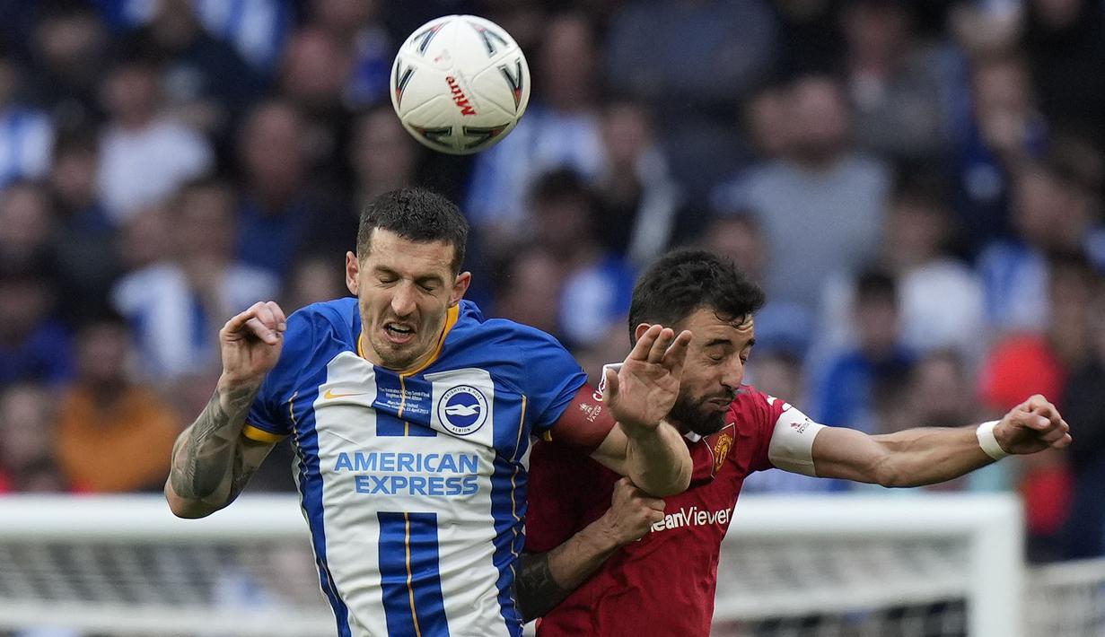 Pemain Manchester United, Bruno Fernandes (kanan) berebut bola dengan pemain Brighton, Lewis Dunk saat laga semifinal Piala FA 2022/2023 di Stadion Wembley, London, Minggu (23/04/2023). MU menang dengan skor 7-6 pada babak adu penalti. (AP Photo/Alastair Grant)