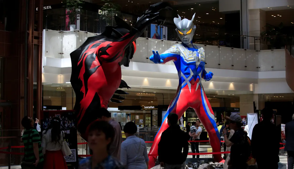 Pengunjung mengamati dua patung Ultraman setinggi lima meter yang dipamerkan di pusat perbelanjaan di Shanghai, China, Selasa (3/5/2016). Patung tersebut merupakan bagian dari pameran untuk memperingati ulang tahun Ultraman ke-50. (REUTERS/Aly Song)