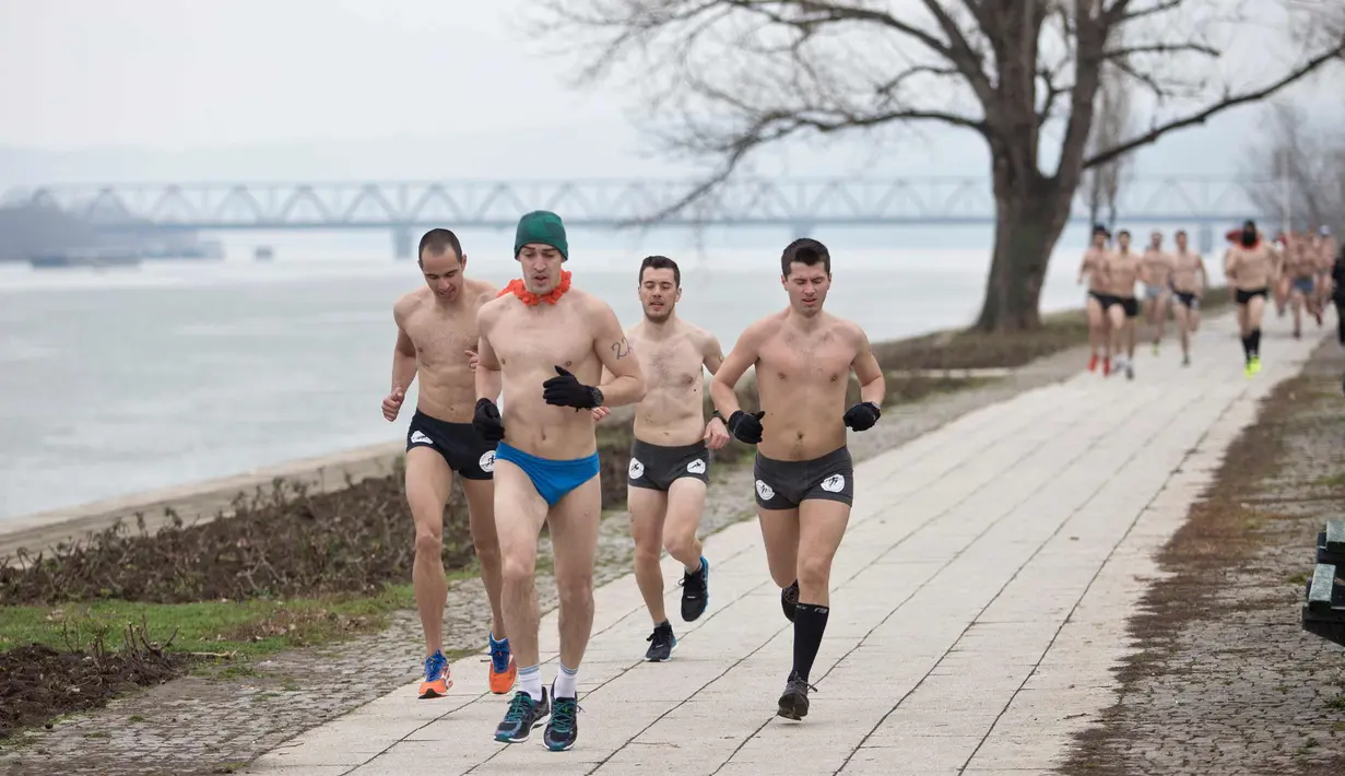 Peserta berlari saat mengikuti lomba Underpants Run di tepi sungai Danube di Beograd, Serbia (4/2). Dengan hanya mengenakan pakaian dalam para peserta tetap semangat mengikuti lomba dengan suhu mendekati nol derajat Celcius. (AP Photo/Marko Drobnjakovic)