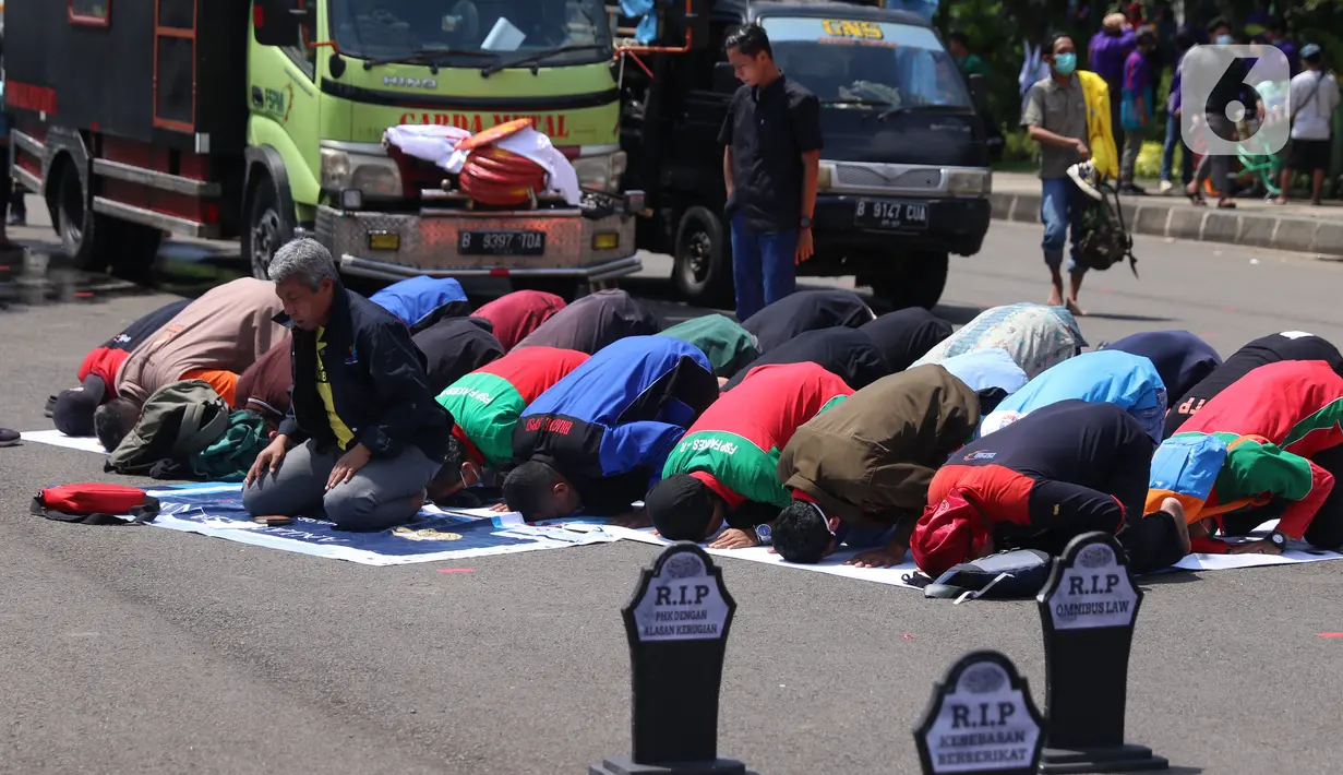 Sejumlah buruh menunaikan salat zuhur di sela aksi Hari Buruh Internasional atau May Day di Jakarta, Sabtu (1/5/2021). Sejumlah massa yang tergabung dalam serikat pekerja menggelar unjuk rasa di Hari Buruh ini. (Liputan6.com/Angga Yuniar)