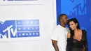 Kemesraan pasangan seleb, Kim Kardashian dan Kanye West di karpet merah penghargaan MTV VMA 2016 di New York, Minggu (28/8). Malam itu, Kanye West memilih T-shirt, jeans sampai sepatu yang seluruhnya berwarna putih. (AFP PHOTO/Angela Weiss)