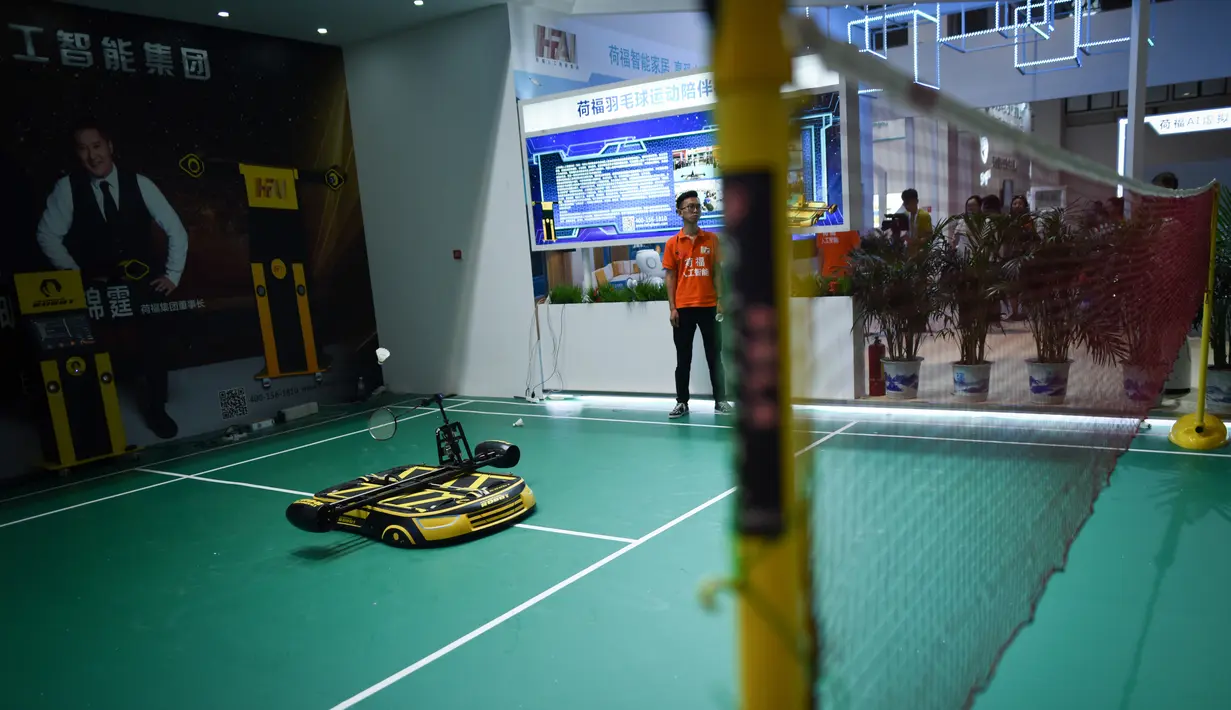 Sebuah robot bermain bulutangkis dengan seorang pria pada Konferensi Robot Dunia 2018 di Beijing, China, Rabu (15/8). (WANG Zhao/AFP)