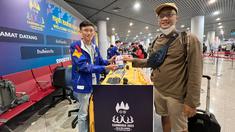 Jurnalis Bola.com, Gregah Nurikhsan (kanan) memegang ID card peliputan SEA Games 2023 Kamboja yang telah diregistrasi oleh petugas di Bandara Internasional Phnom Penh, Kamboja, pada Jumat (28/4/2023). Proses registrasi berupa penempelan hologram untuk kontingen dan wartawan. (Bola.com/Abdul Aziz)