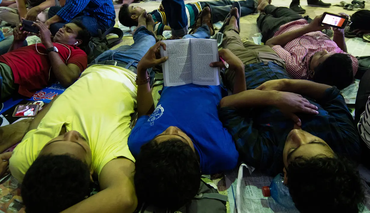 Calon pembeli tidur saat mengantre demi mendapatkan tiket mudik lebaran di Stasiun Kereta Kamalapur, Dhaka, Minggu (3/7). Perayaan Idul FItri merupakan salah satu tradisi yang terbesar di Bangladesh. (AFP PHOTO/MUNIR UZ ZAMAN)