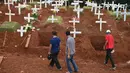 Keluarga korban yang meninggal karena virus corona COVID-19 melewati sejumlah makam di sebuah pemakaman di Jakarta, Rabu (15/4/2020). Hingga sore ini, jumlah kasus COVID-19 di Indonesia sebanyak 5.136 positif, 446 sembuh, dan 469 meninggal dunia. (Bay ISMOYO/AFP)