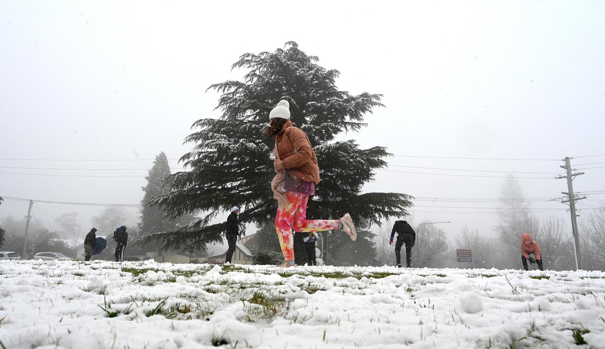 Orang-orang menikmati hujan salju pertama musim ini di Katoomba di pegunungan Blue Mountains, Kamis (10/6/2021). Katoomba berada di New South Wales, selatan Australia atau 102 kilometer sebelah barat Sydney.  (AFP/Saeed KHAN)