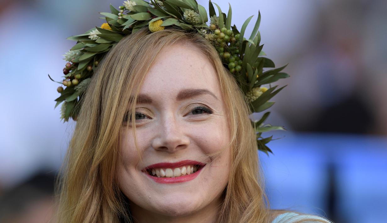 Seorang suporter cantik menggunakan mahkota dari daun saat menonton Islandia melawan Argentina pada laga grup D di Spartak Stadium, Moskow, (16/6/ 2018). Argentina dan Islandia bermain imbang 1-1. (AFP/Juan Mabromata)