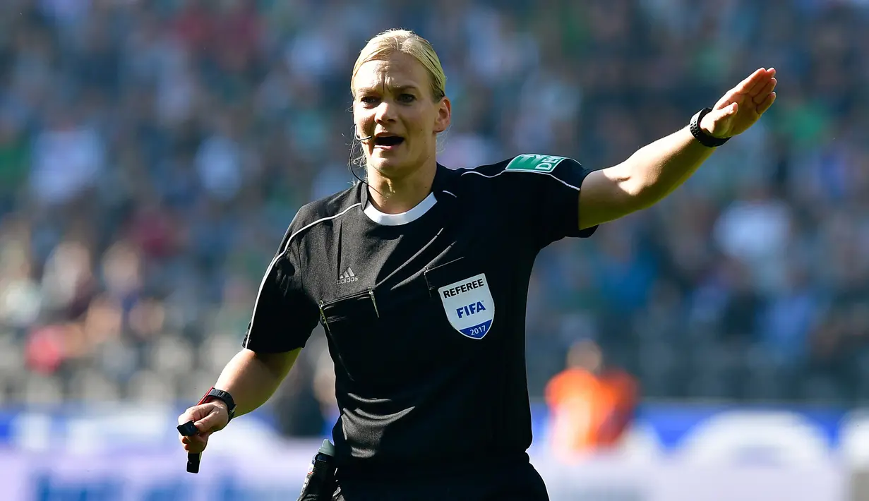 Wasit wanita, Bibiana Steinhaus saat memimpin pertandingan Hertha Berlin melawan Werder Bremen di Berlin (10/9). Bibiana Steinhaus adalah wanita pertama yang menjadi wasit di kompetisi tertinggi Liga Jerman, Bundesliga. (AFP Photo/Tobias Schwarz)