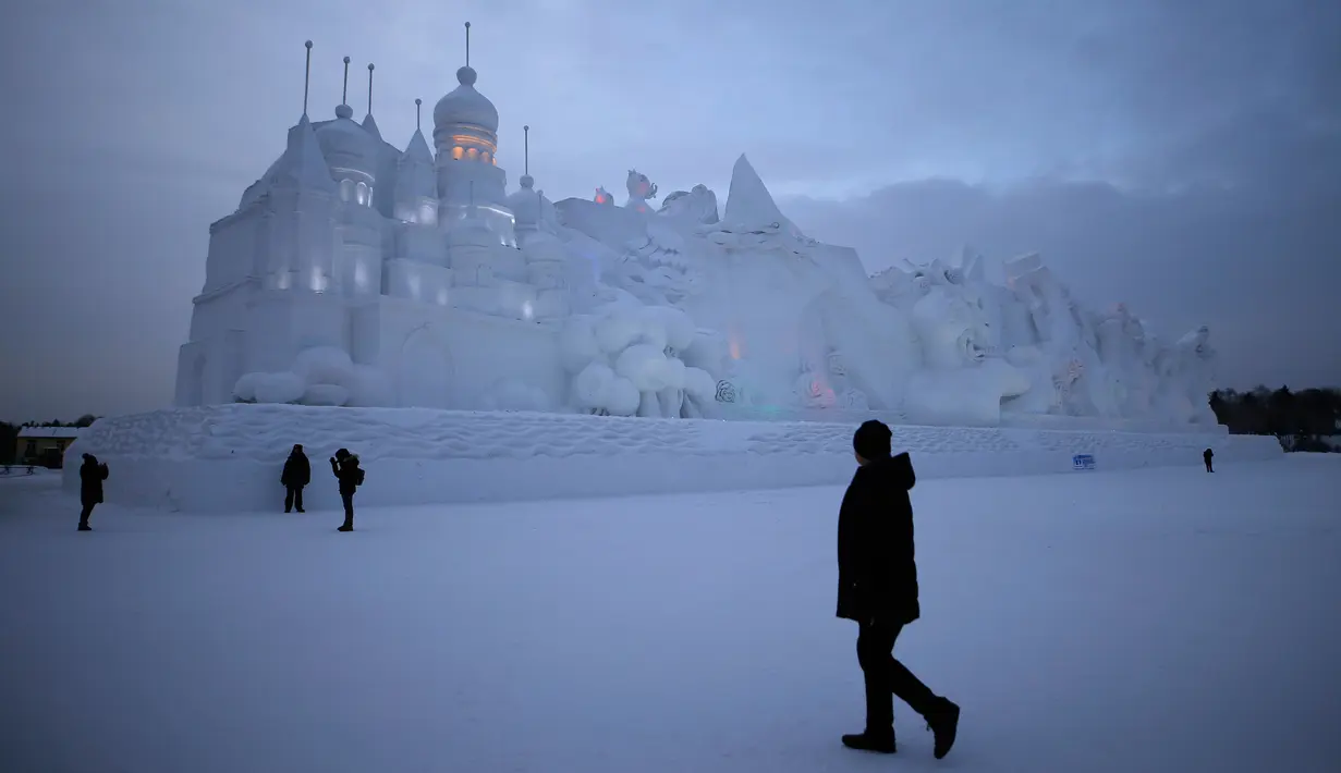 Sejumlah Pengunjung berjalan ditempat wahana es yang berda di kota utara Harbin, provinsi Heilongjiang , Cina, (5/1). Bangunan es yang dibuat menyerupai Istana dengan ukuran yang besar. (REUTERS/Aly Song)