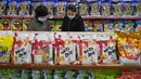 Orang-orang melihat-lihat jajanan merek Taeha yang diproduksi oleh Pabrik Bahan Makanan Unha Taesong di sebuah toko di Pyongyang, Korea Utara, 6 April 2021. (KIM Won Jin/AFP)
