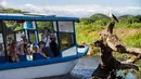 Para wisatawan menggunakan sebuah perahu menyusuri Sungai Tarcoles, Rio Grande, Kosta Rika, Jumat (13/3/2015). Habitat alami menjadi daya tarik objek wisata Sungai Tarcoles. (AFP Photo/Ezequiel Becerra)