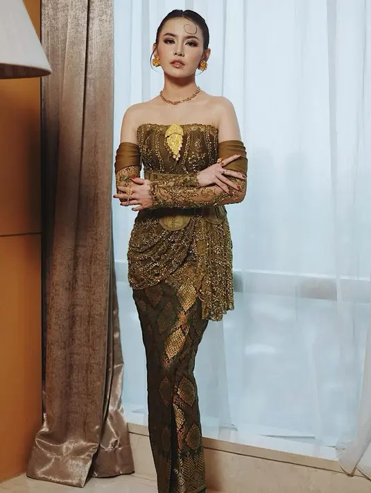 Mahalini Raharja tampil paripurna dengan desain kebaya yang paling beda. Menampilkan strapless top dengan detail korset dan asymetrical ruffle. Dipadukan dengan rok tenun dan gloves brukat yang jadi aksen sabrina [@askyfebrianti]